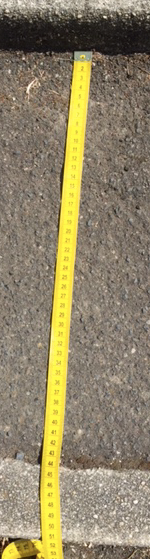Image of a tape measure being used to measure the depth of a step.