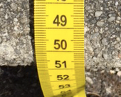Close-up image of a tape measure being used to measure the depth of a step.